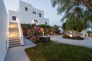 a large white building with stairs and a yard at Maison Palms in Mesaria