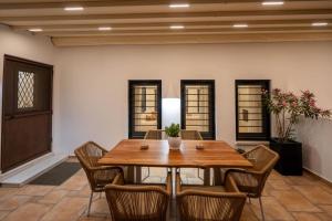 a dining room with a wooden table and chairs at Maison Palms in Mesaria