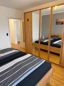 a bedroom with two beds and a large mirror at FeWo Susanne in Wiehl