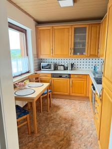 a kitchen with wooden cabinets and a small table at FeWo Susanne in Wiehl