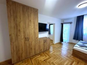a room with a large wooden cabinet with a flat screen tv at Pater Apartments and Rooms in Siófok