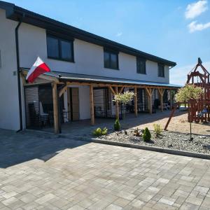 a house with a flag on the front of it at Kameralne Kładno in Łopienica