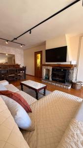 a living room with two beds and a tv at Gredos Tiétar in El Arenal