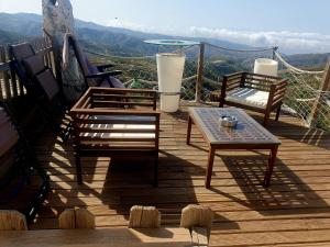 a wooden deck with two chairs and a table at Cortijo Saucillo in Albondón
