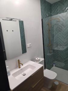 a bathroom with a sink and a toilet and a mirror at Pasaje Plaza Apartamento in Alcazar de San Juan +7 photos