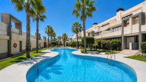 a swimming pool with palm trees in front of a building at Torrevieja - La Mata Beach First Line New Apartments 2024r in La Mata
