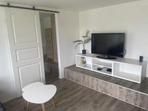 a living room with a flat screen tv on a shelf at Apartment Frøya in Sætra