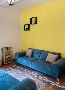 a blue couch in a living room with a yellow wall at Kandy Living Homestay in Kandy