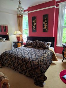 a bedroom with a bed and a red wall at Beggar's Knap in Dorchester