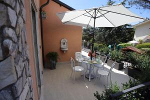 a patio with a table and chairs and an umbrella at La Genziana - villino con parcheggio privato in Popoli