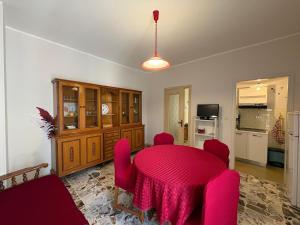 a dining room with a pink table and chairs at Appartamento Iris in Torre Pellice