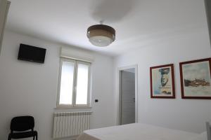 a white bedroom with a bed and a window at La Genziana - villino con parcheggio privato in Popoli