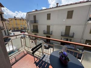 a balcony with a table and chairs and a building at Appartamento Iris in Torre Pellice