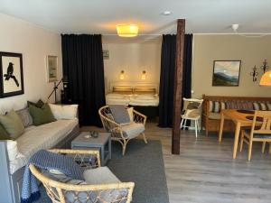 a living room with a couch and chairs and a table at Enkelheten i Kivik in Kivik