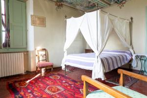 a bedroom with a canopy bed and a chair at Casa Giulia in Castagnole Lanze