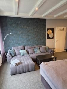 a living room with a couch and a table and a wall at Zur schönen Aussicht in Langenfeld