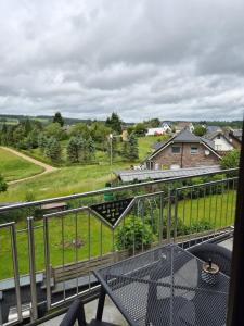 a balcony with a table and a view of a field at Zur schönen Aussicht in Langenfeld +2 photos