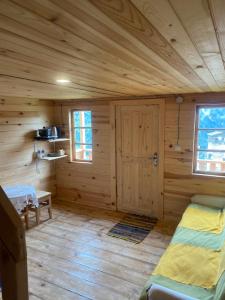 a log cabin with a bed and a door at Towers Inn Cottage in Mestia