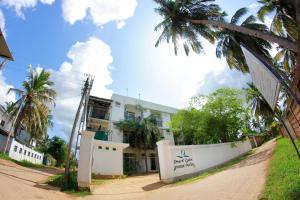 a building on the side of a street with palm trees at Hotel Pearl Gate in Chilaw
