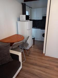 a small kitchen with a wooden table and a table and chairs at Studio UN Hagoort in Agde