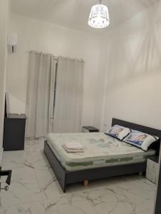 a bedroom with a bed and a chandelier at Erna Apartment in Golem