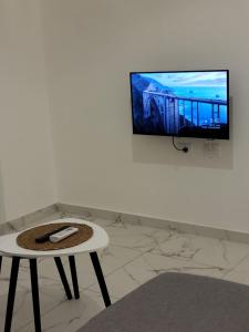 a room with a table and a tv on a wall at Erna Apartment in Golem +3 photos
