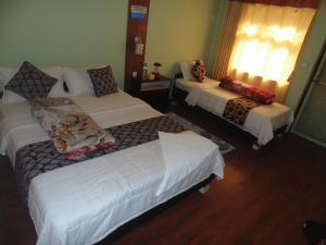 Cette chambre comprend 3 lits et une fenêtre. dans l'établissement River Fun Beach Resort, à Gorkhā