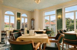 a restaurant with tables and chairs and windows at Aleksov Complex Sans Souci in Ognyanovo