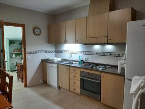 a kitchen with wooden cabinets and a stove top oven at La Venta Casa Rural in Benitachell