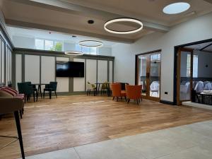 a room with a table and chairs and a tv at The Raven Hotel in Corby
