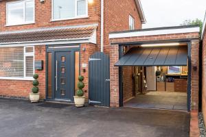 a garage with a blue door on a brick building at Triumph House in Hinckley