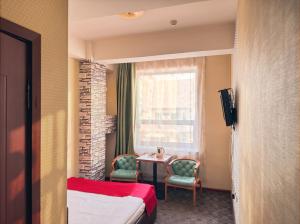 a hotel room with a bed and a table and chairs at Twin Horse Hotel in Ulaanbaatar