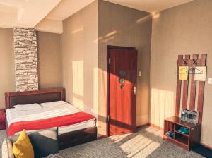a bedroom with a bed and a red door at Twin Horse Hotel in Ulaanbaatar