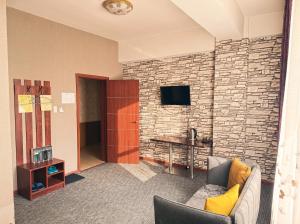 a living room with a couch and a brick wall at Twin Horse Hotel in Ulaanbaatar +13 photos
