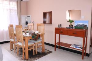 a dining room with a table and chairs and a desk at Kiliheights Getaway in Sanya Chini Station