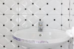 a white sink in a white tiled bathroom at Vila Enea in Ksamil +95 photos