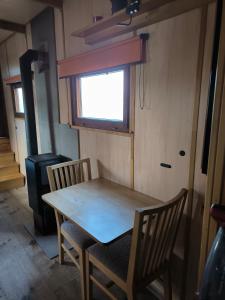 a table and two chairs in a room with a window at Hausbót Slapy in Dublovice