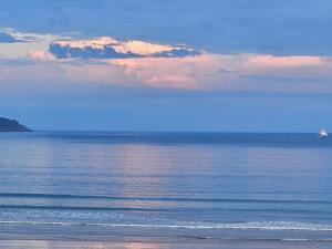 a view of the ocean with a ship in the distance at les Arômes in Locronan