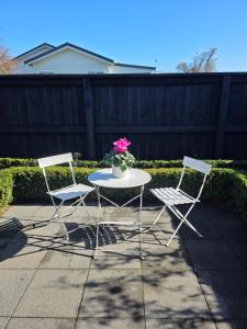 two chairs and a table with a vase of flowers at Changing Seasons in Cambridge