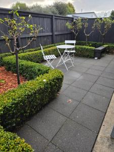 a patio with two chairs and a table in a garden at Changing Seasons in Cambridge