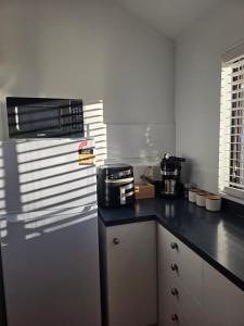 a kitchen with a black counter top with a toaster oven at Changing Seasons in Cambridge