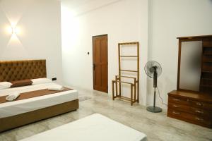 a bedroom with a bed and a dresser and a mirror at Danu Homestay Kandy in Kandy
