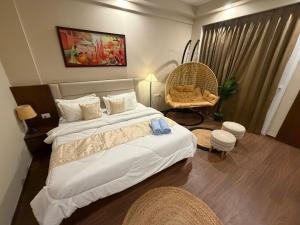 a hotel room with two beds and a chair at Luxury Swing Suite - Bliss Suites in Greater Noida