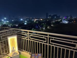 a balcony with a view of a city at night at Luxury Swing Suite - Bliss Suites in Greater Noida