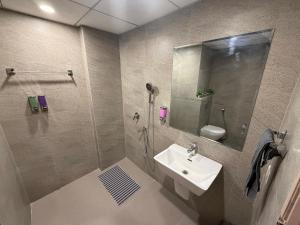 a bathroom with a sink and a shower with a mirror at Luxury Swing Suite - Bliss Suites in Greater Noida +20 photos
