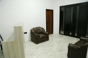 a living room with two leather chairs and a table at Danu Homestay Kandy in Kandy