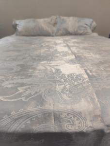 a bed with a white blanket on top of it at A Great Guest House Grootfontein in Groutfontein
