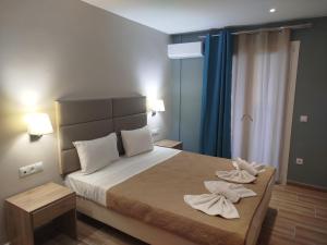 a bedroom with a bed with towels on it at Frosini Gardens in Kassiopi