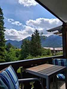 a table and chairs on a balcony with a view of mountains at Gästehaus Zunterer in Wallgau