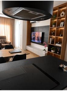 a living room with a dining table and a television at Euforia Ma Apartment Sarajevo in Sarajevo